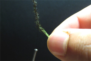 Trenzaremos las fibras de pavo real con el hilo de montaje